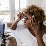 Kobieta wykonuje dzienny makijaż, nagrywając tutorial telefonem