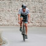 Kolarz szosowy w pełnym stroju jedzie szybko podczas wyścigu