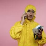 Osoba w żółtym kombinezonie ochronnym rozmawia przez telefon
