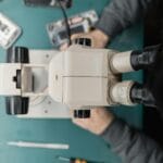 Serwisant naprawiający telefon pod mikroskopem podczas precyzyjnych prac