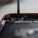 Serwisant naprawiający wnętrze smartfona precyzyjnymi narzędziami