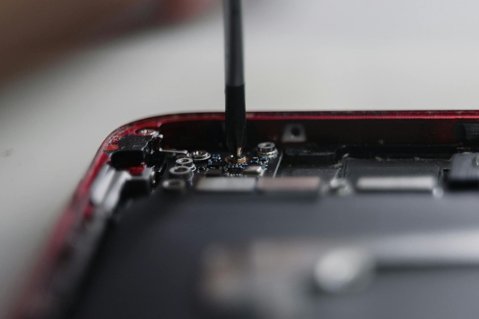 Serwisant naprawiający wnętrze smartfona precyzyjnymi narzędziami