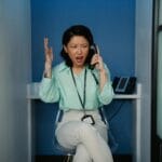 Zirytowana kobieta w biurze rozmawia przez telefon z cichym dźwiękiem