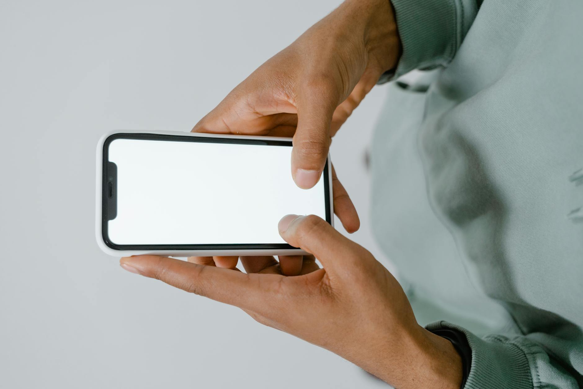 Dłonie trzymające smartfon z wygaszonym ekranem podczas naprawy