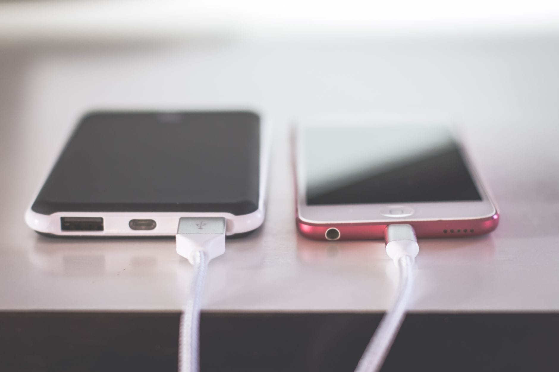 Dwa smartfony ładujące się równocześnie na biurku