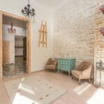 Jasny salon vintage z ceglaną ścianą, retro meblami i kolorowym żyrandolem