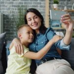 Mama z synem robią selfie na kanapie smartfonem