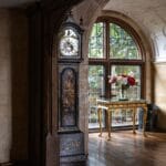 Salon w angielskim stylu z zegarem stojącym i kwiatami przy oknie