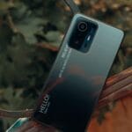 Smartfon z bliska na tle natury, widoczne detale obudowy