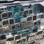 Płytki drukowane smartfonów w plastikowym pojemniku w fabryce elektroniki