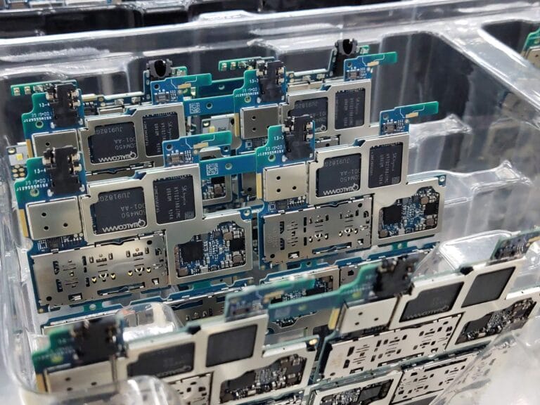 Płytki drukowane smartfonów w plastikowym pojemniku w fabryce elektroniki